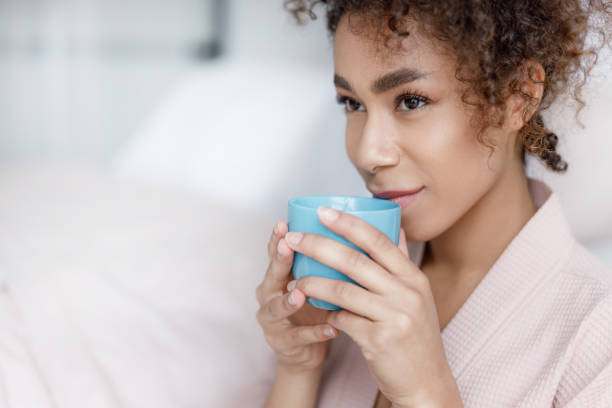 istock Attractive Afro American lady drinking coffee and smiling 1190403295