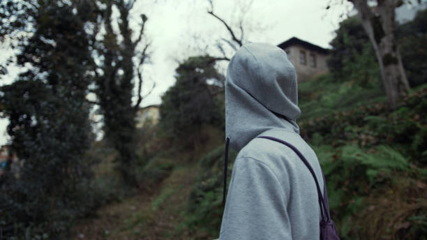 istock Back view of a male man with backpack walking in an old path in woods 1190403377
