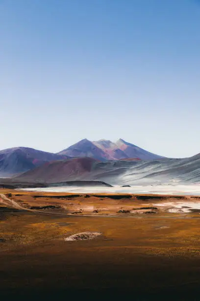 Scenic view of salt flat, volcanoes sand dunes and road in Atacama, Chile