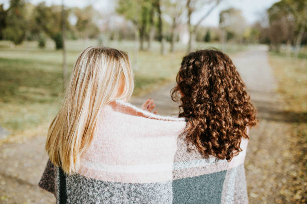 istock Two beautiful young women enjoying a fall day covered with scarf 1190408291