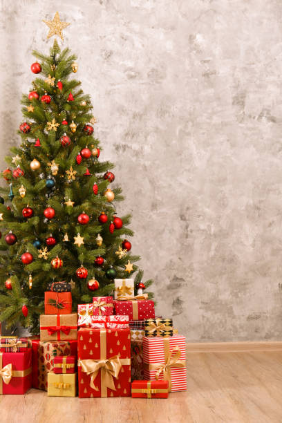 istock Decorated Christmas tree in soft yellow lights with bokeh effect background. Lofty apartment with traditional new year holiday decoration, intimate lighting. Close up, copy space. 1190409218