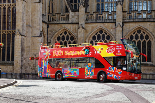 Open top red tourist bus passing the Abbey. Very colourful vehicle.