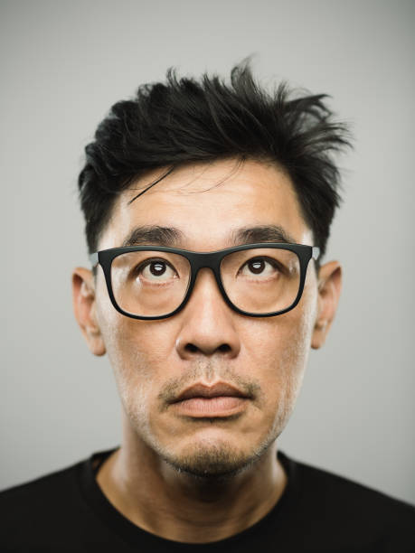 istock Portrait of a real chinese man with blank expression looking up 1190412623