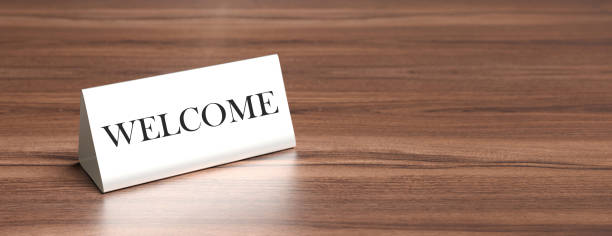 istock Welcome table tent on a wooden table, copy space. 3d illustration 1190413484