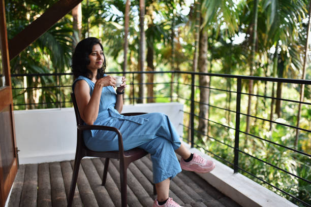 istock Woman having tea sitting in the balcoby 1190417447