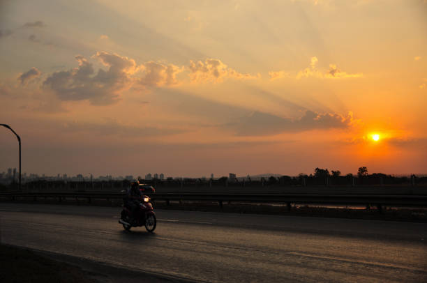 istock riding moped under the sunset 1190417999