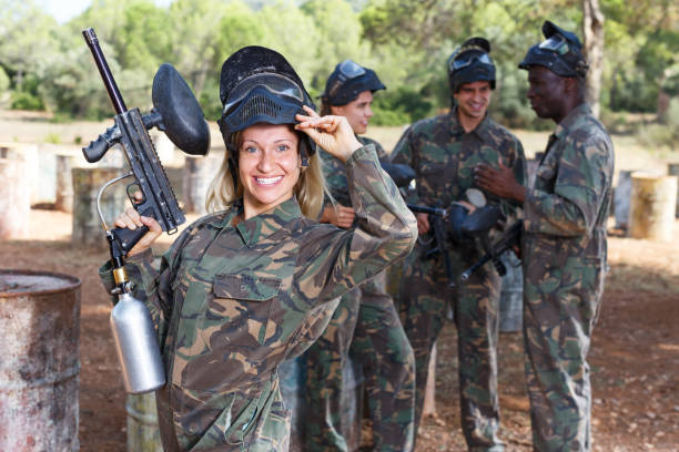 istock Woman paintball player standing with gun 1190419122