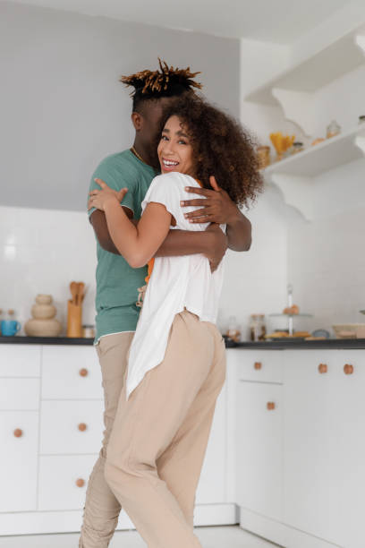 istock Happy loving couple hugging in kitchen at home 1190419211