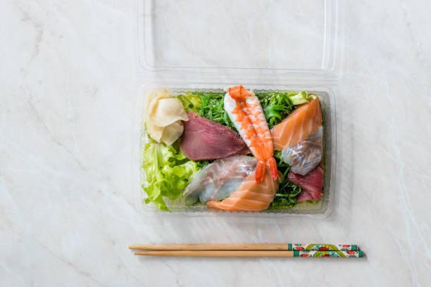 take away sashimi salat mit wakame, algen, lachs, seebarsch, garnelen, kani, makrele fisch, thunfisch in kunststoff-box-paket / behälter. - sashimi sushi salad sea stock-fotos und bilder