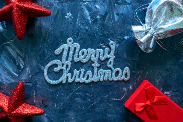 istock Merry Christmas words and gift boxes with red stars on grey 1190420575