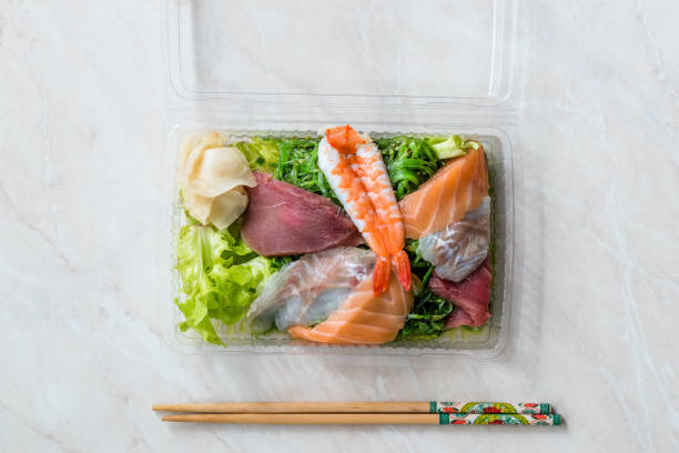 take away sashimi salat mit wakame, algen, lachs, seebarsch, garnelen, kani, makrele fisch, thunfisch in kunststoff-box-paket / behälter. - sashimi sushi salad sea stock-fotos und bilder