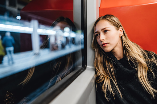 Portrait of a young pretty Caucasian woman in subway train.