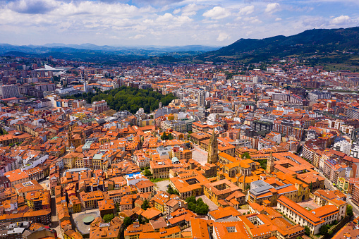 Panoramic aerial view of Oviedo city surrounded by mountain ranges on sunny summer day, Asturias, Spain