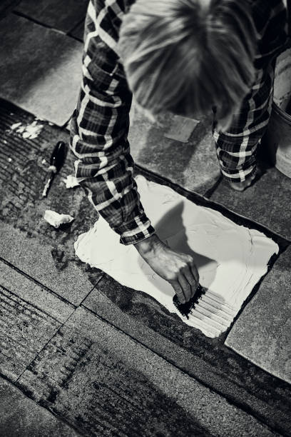 istock Woman tiling a kitchen floor 1190424970