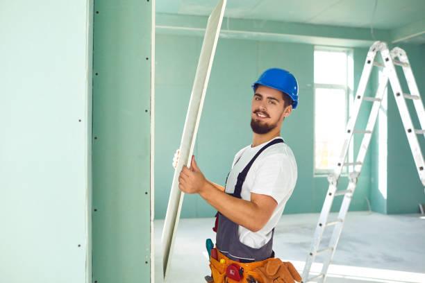 Worker builder installs plasterboard drywall at a construction stock photo