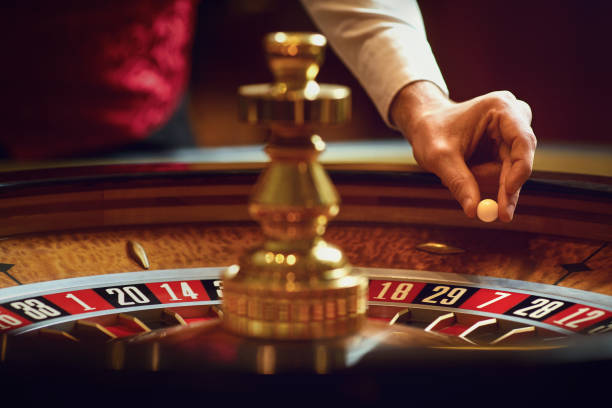 рука крупье с мячом на колесе рулетки во время игры в казино. - casino roulette gambling casino worker стоковые фото и изображения