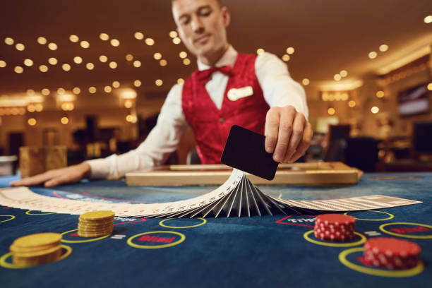 croupier tiene le carte da poker tra le mani a un tavolo in un casinò. - croupier foto e immagini stock