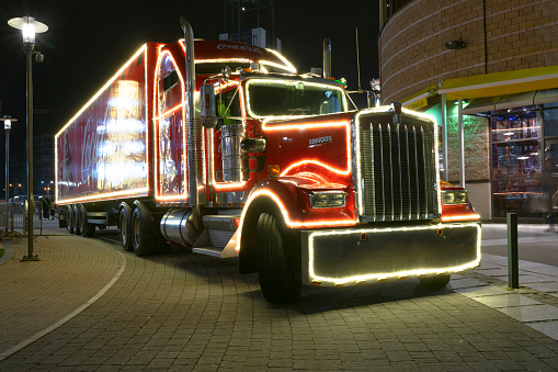 Warsaw, Poland - 8th December, 2018: Kenworth Coca-Cola truck stopped on a street at night. Classic american trucks are used to Christmas advertisement in Europe.