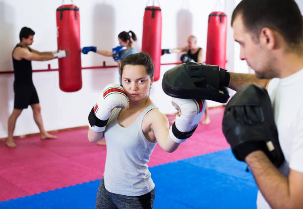 istock Sportswomen competing in colored boxing gloves 1190430022