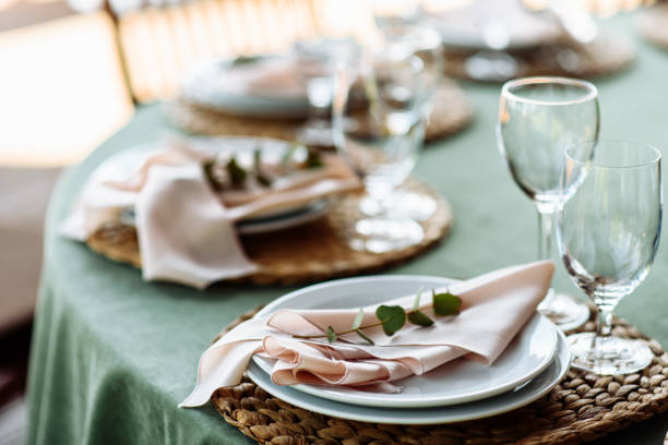 istock Festive table setting. Plates decorated with eucalyptus branches and elegant napkins in nude colors. 1190430262
