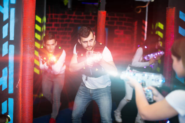 istock Excited guy laser tag player in bright beams 1190430764