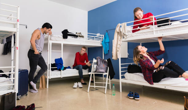 istock Young men and women friendly interacting while staying in modern comfy hostel 1190430827