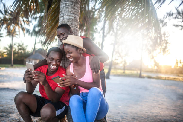 istock Friends sitting outdoors holding cell phones 1190431066