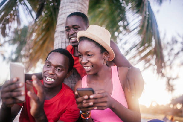 istock Friends sitting outdoors holding cell phones 1190431781