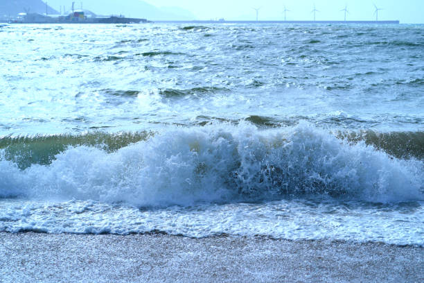 Big dangerous waves of the Atlantic Ocean run onto the sandy shore in summer day. Natural fresh background for poster, banner, postcard, greeting card, touristic guide.