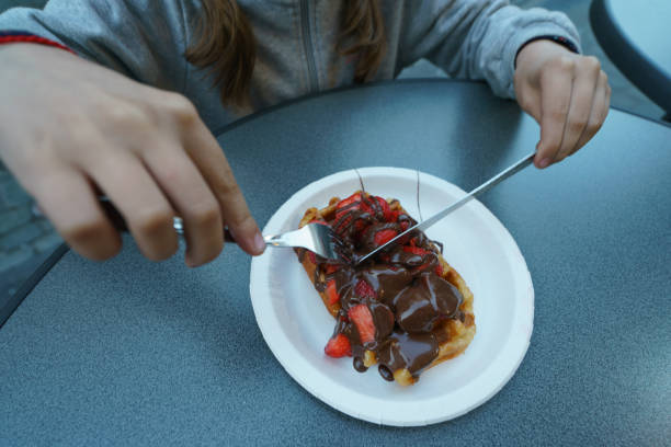 chica comiendo los gofres belgas más deliciosos - brussels waffle belgian waffle people fotografías e imágenes de stock