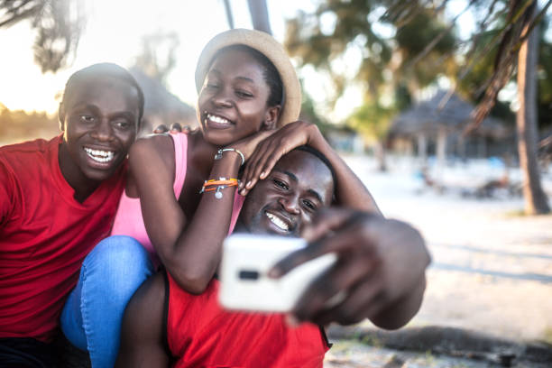 istock Friends sitting outdoors holding cell phones 1190431947