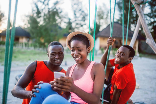 istock Friends sitting outdoors holding cell phones 1190431950