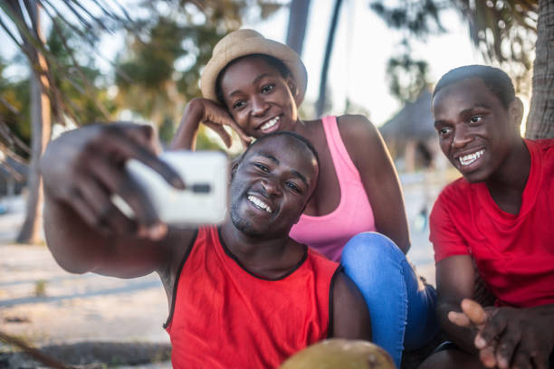 istock Friends sitting outdoors holding cell phones 1190432052