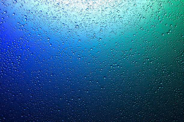 istock Water droplets on a translucent rainbow glass background with gradient 1190433624