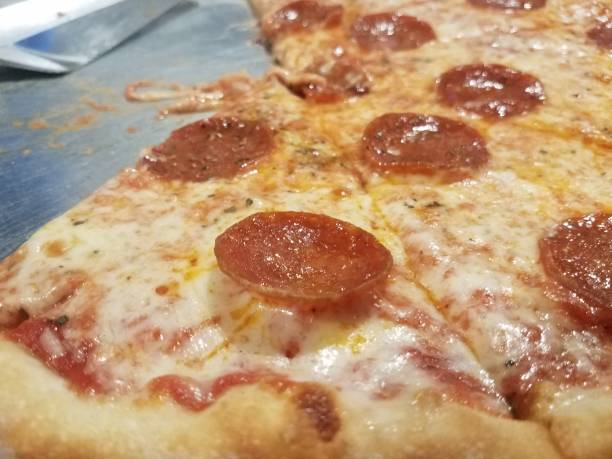 istock greasy cheese and pepperoni pizza on metal tray with spatula 1190434048