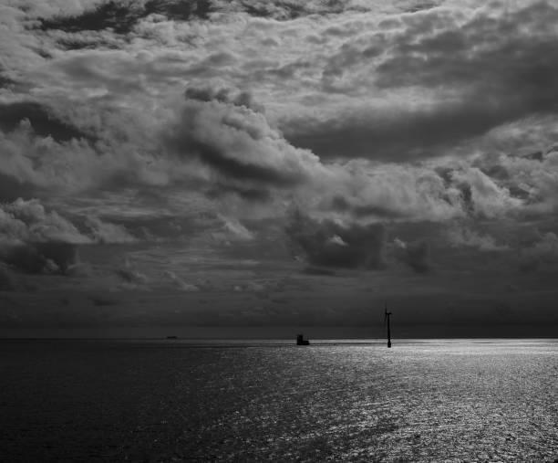 istock Dawn with cloudy sky and windmill on the sea 1190434698