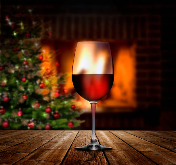 Glas of Red wine at a fire lace with Christmas Tree