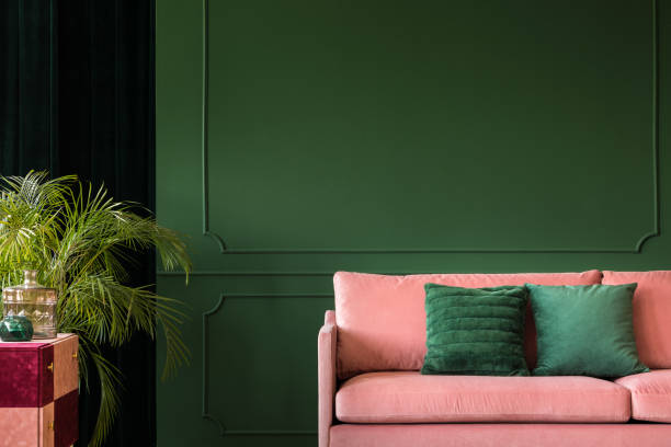 istock Pink sofa in front of green wall with moldings 1190436408