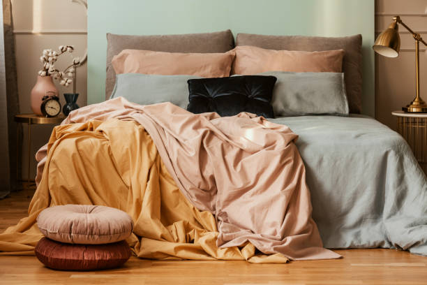 istock Pastel blue, pink and orange bedding on double bed in chic bedroom interior 1190436704