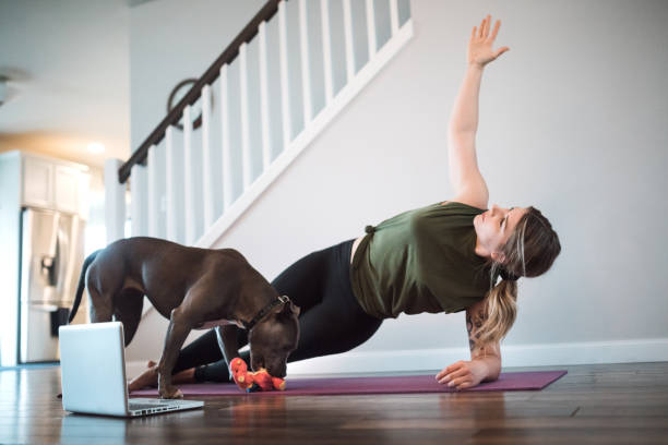 istock Woman Watching Yoga Tutorials Online With Her Dog 1190437476