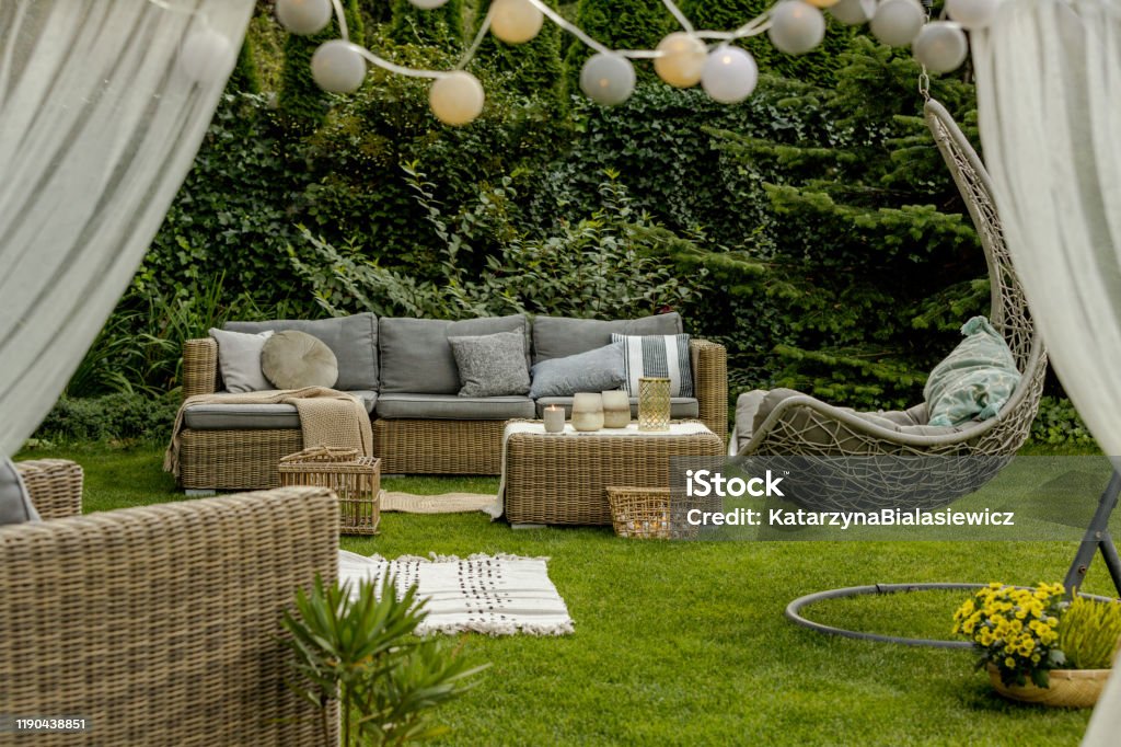 Pretty decorated garden Pretty and cozy decorated garden with sofa and hanging chair Yard - Grounds Stock Photo