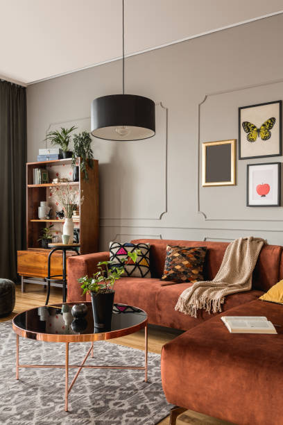 istock Elegant coffee table in front trendy sofa in modern living room interior with grey wall 1190440283