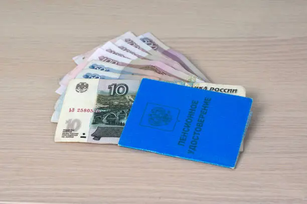 Russian pension certificate and Russian small money - 10, 50, 100, 500 rubles. It is written in Russian "Pension Certificate". Pension reform concept