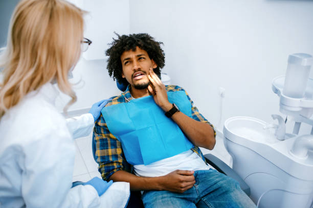 mann mit zahnschmerzen beim zahnarzt - zahnschmerz stock-fotos und bilder