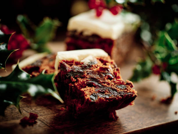 Two chocolate pies, one pavé and one chestnut pie with very red cherries, on the table little balls and Christmas decorations.