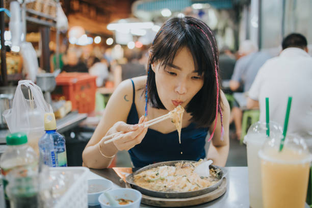 południowo-wschodniej azji kobieta cieszyć się jedzenie sukiyaki na nocnym rynku ulicznym, - thailand soup thai ethnicity thai culture zdjęcia i obrazy z banku zdjęć