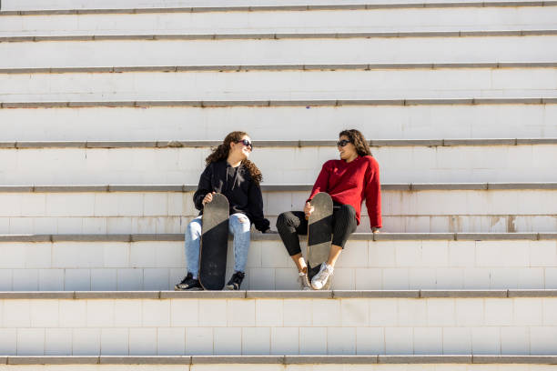 istock Two happy teen skaters resting on the stairs 1190443679