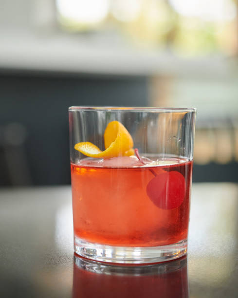 istock Red alcoholic beverage drink with a sphere ice red cherry and orange zest for decoration 1190443831