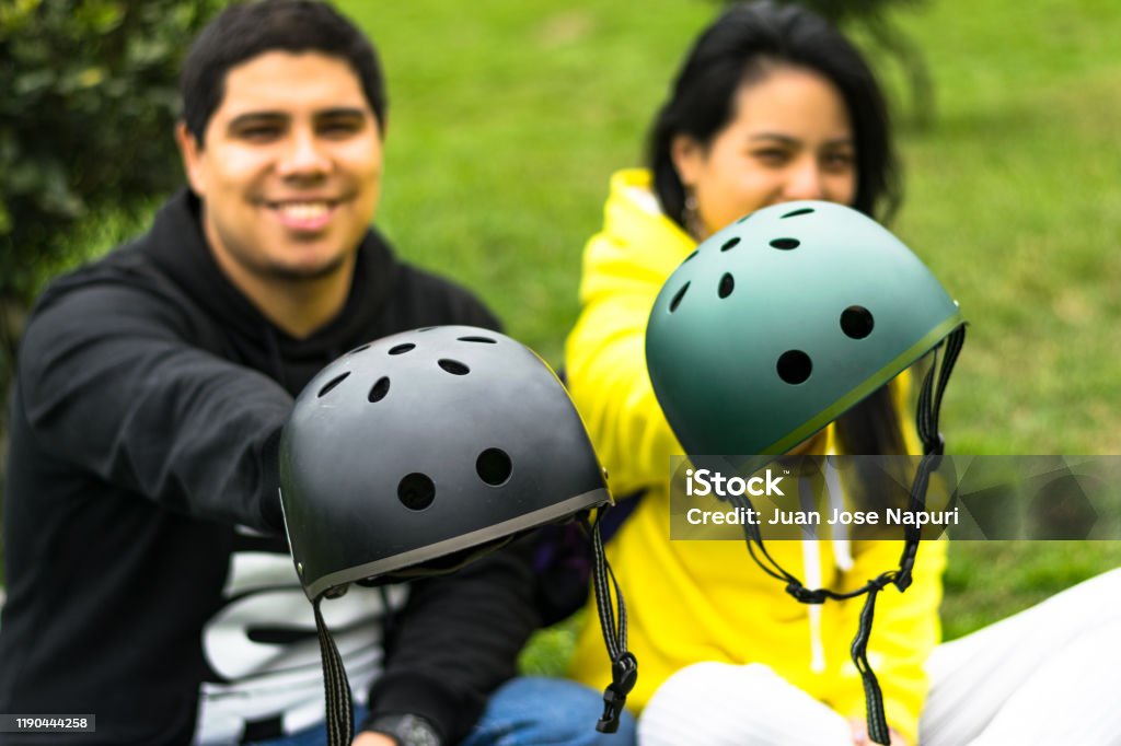 Dos amigos sonrientes mostrando casco - Foto de stock de Casco de Ciclista libre de derechos