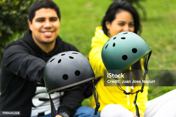 Dos Amigos Sonrientes Mostrando Casco Foto de stock y más banco de imágenes de Casco de Ciclista - Casco de Ciclista, Casco de deportes, Ciclomotor de movilidad